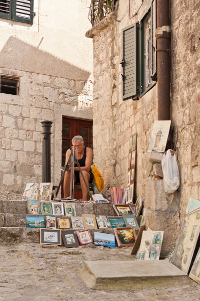 Uliczny malarz w Starym Mieście w Kotorze.